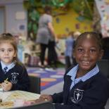Two school girls sitting at a table Two school girls sitting at a table